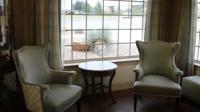 Cozy sitting area with chairs and side table near a window