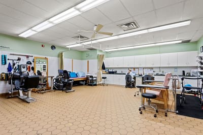 A rehabilitation therapy room with equipment and staff