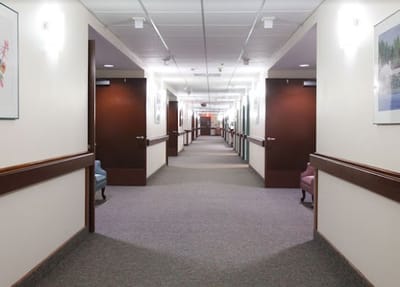 A hallway with lighted ceiling and seating areas