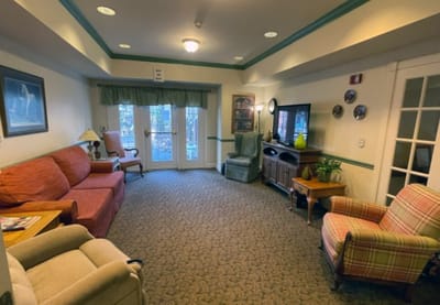 Common area with seating and TV in a senior living facility
