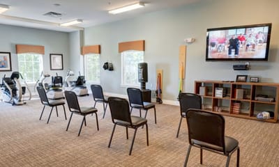 Interior view of an activity room with chairs and a TV