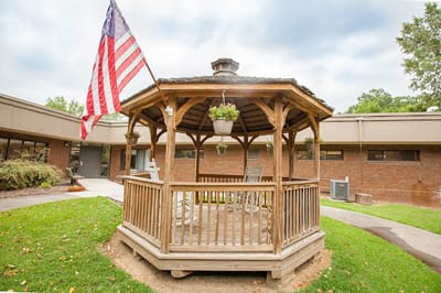 Wooden gazebo with rocking chairs and an American flag