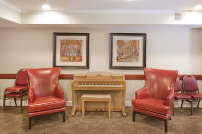 Interior common area with red chairs and a piano