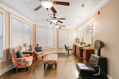 Bright salon area with floral chairs and mirrors