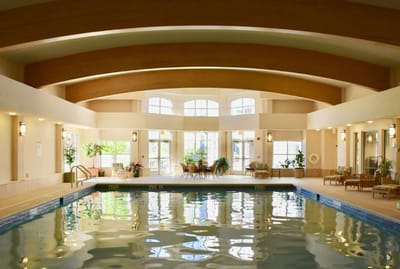 Indoor swimming pool area with seating and large windows