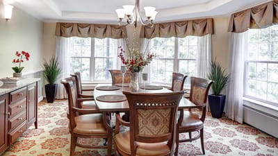 Bright dining room with a large wooden table and floral decor