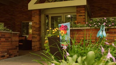 Entrance with welcome sign and flowers in front