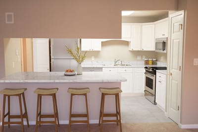 Bright kitchen area with bar stools