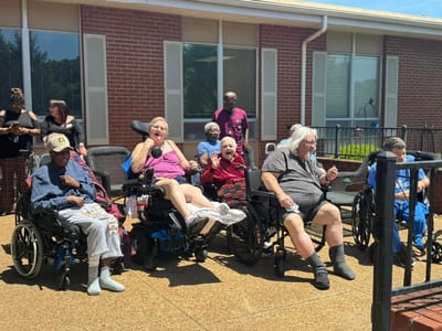 Residents enjoying an outdoor activity in wheelchairs