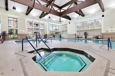 Indoor pool area with spa and seating