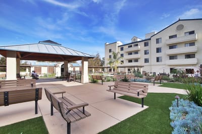 Outdoor seating area with gazebo and building in background