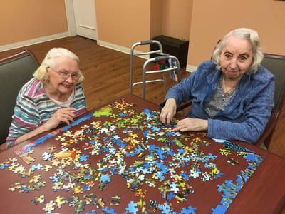 Two residents enjoying a puzzle activity in the common area