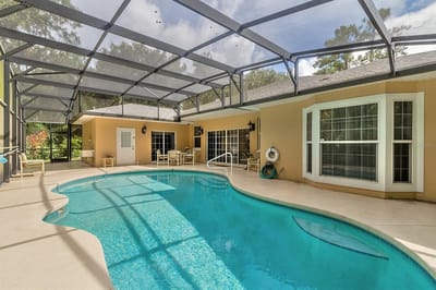 A pool area with seating and large windows