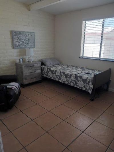 Cozy private resident room with a bed and side table
