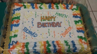 A birthday cake decorated with colorful icing and names
