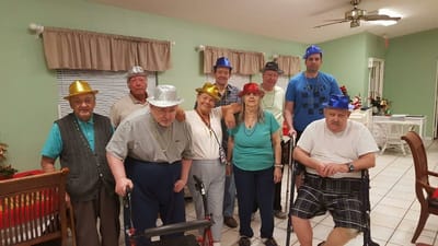 Residents celebrating with festive hats in a common area