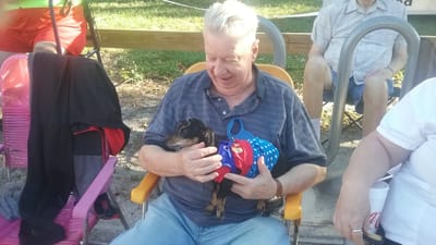 Resident happily holding a small dog