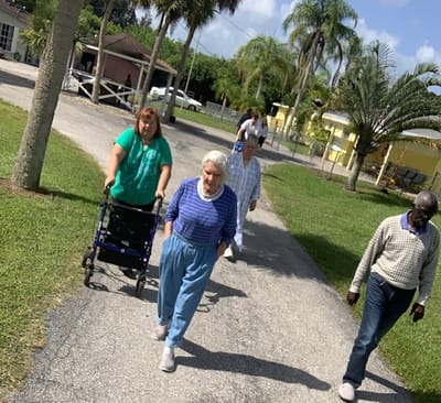 Residents walking along a pathway in a sunny outdoor space