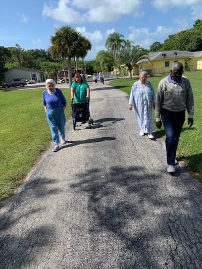 Residents walking on a path in a sunny outdoor area