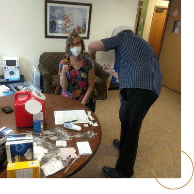 A nurse administering a vaccine to a resident in an indoor setting