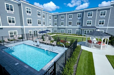 View of a pool area with lounge chairs and gazebo
