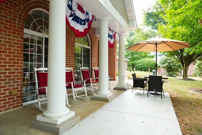 Outdoor seating area with rocking chairs and umbrellas