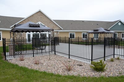 Outdoor seating area with gazebos and fenced garden