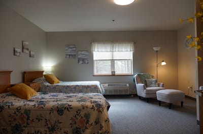 Cozy bedroom with two beds and a reading chair