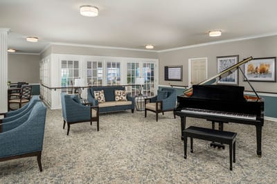 Bright common area with seating and a piano