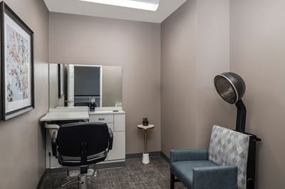 Interior view of a hair salon space with a chair and mirror