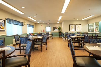 Dining room with tables and chairs set up for residents
