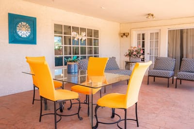 Outdoor dining area with colorful chairs and table