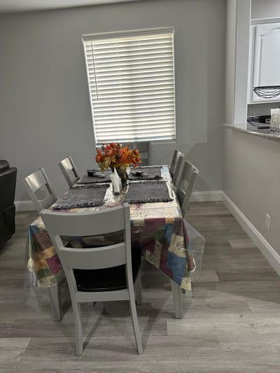 Dining table set with decorative flowers in a facility interior.