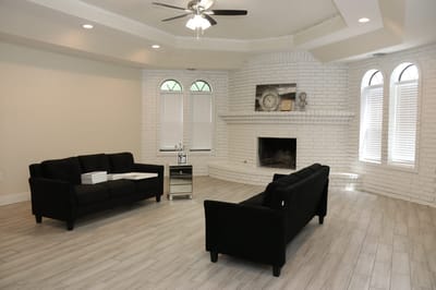 Bright common area with light-colored furniture and a fireplace