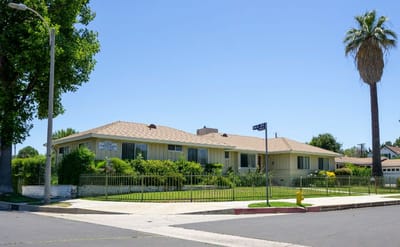 Exterior view of a senior living facility surrounded by greenery