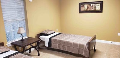 Private resident room with two beds and a lamp