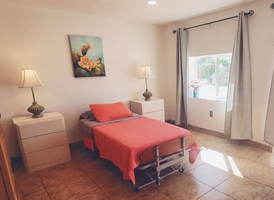 A cozy resident room with a bed and lamps