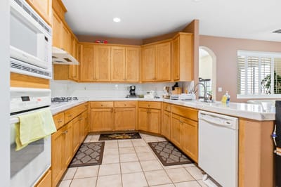 Bright kitchen area with wooden cabinets and appliances