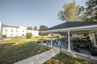 Outdoor seating area with shaded pavilion and green space