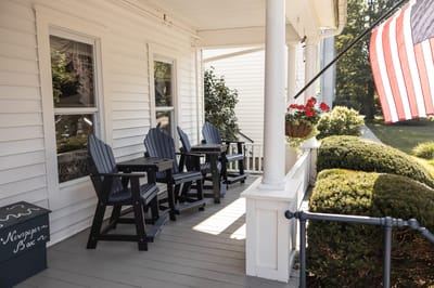 Porch area with outdoor seating and American flag