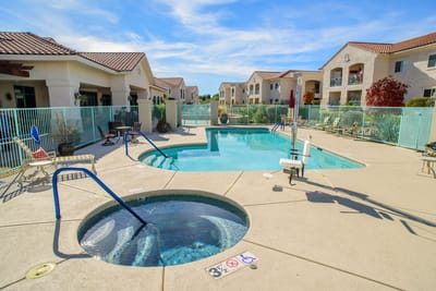 Outdoor swimming pool area with seating and spa