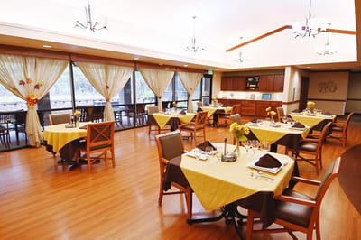 Bright dining room with tables set for residents