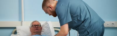 Healthcare worker assisting a resident in bed