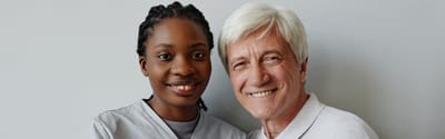 Smiling caregiver and resident in an indoor setting.