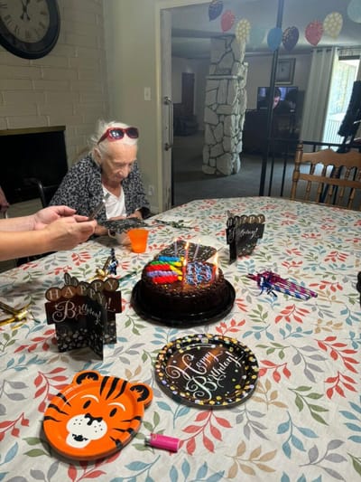Residents celebrating a birthday at a festive table.