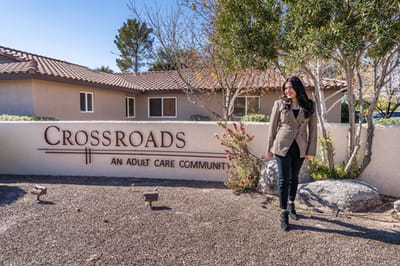A woman posing near the entrance of Crossroads Assisted Living I