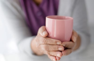 Hands holding a pink cup