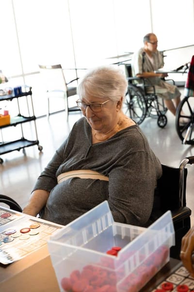 Resident playing bingo in a bright common area