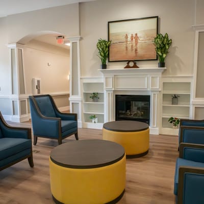 Bright common area with chairs and a fireplace