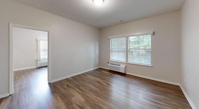 Empty resident room with wooden flooring and window